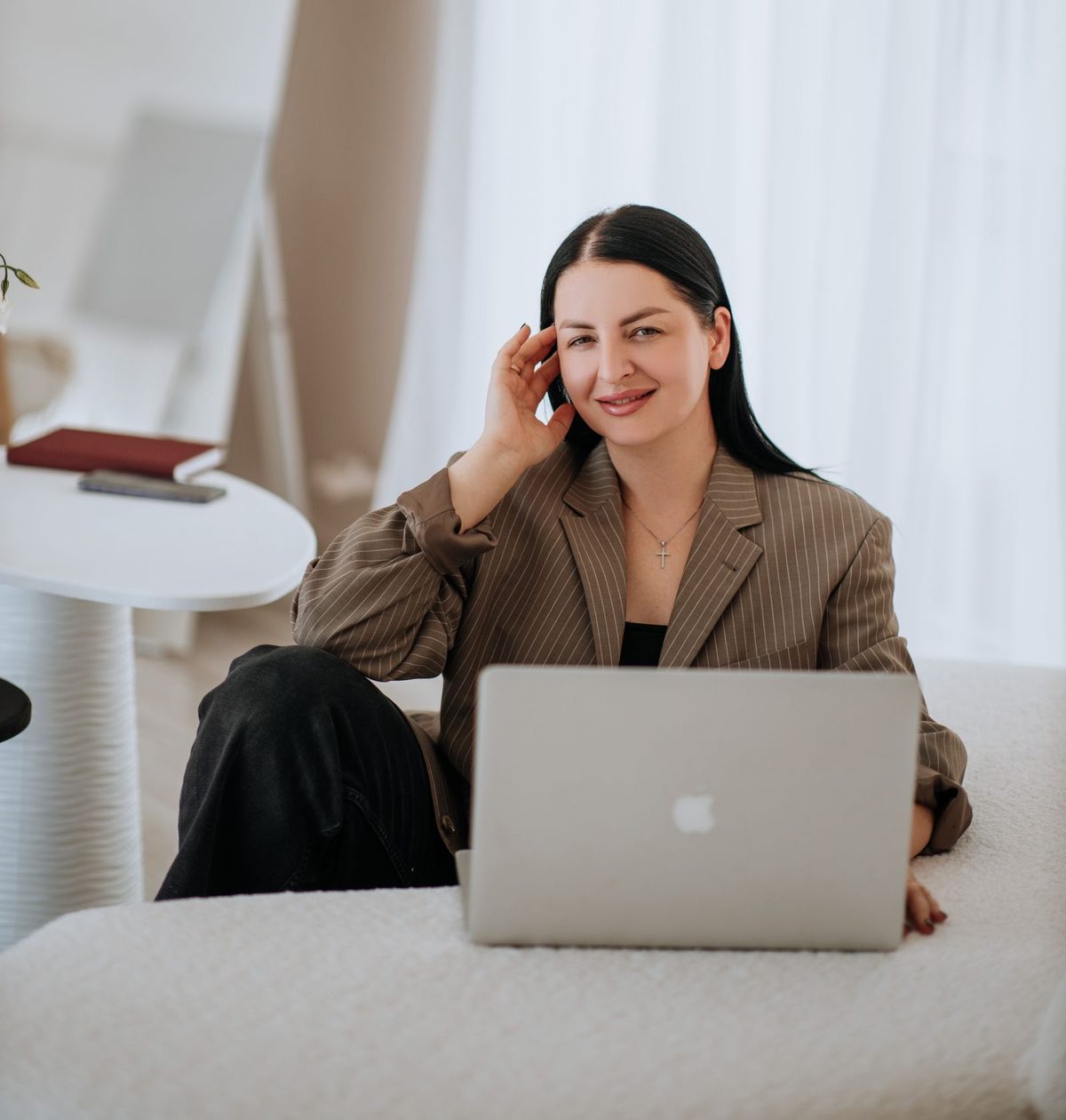 Kobieta w marynarce pracuje na laptopie w jasnym wnętrzu